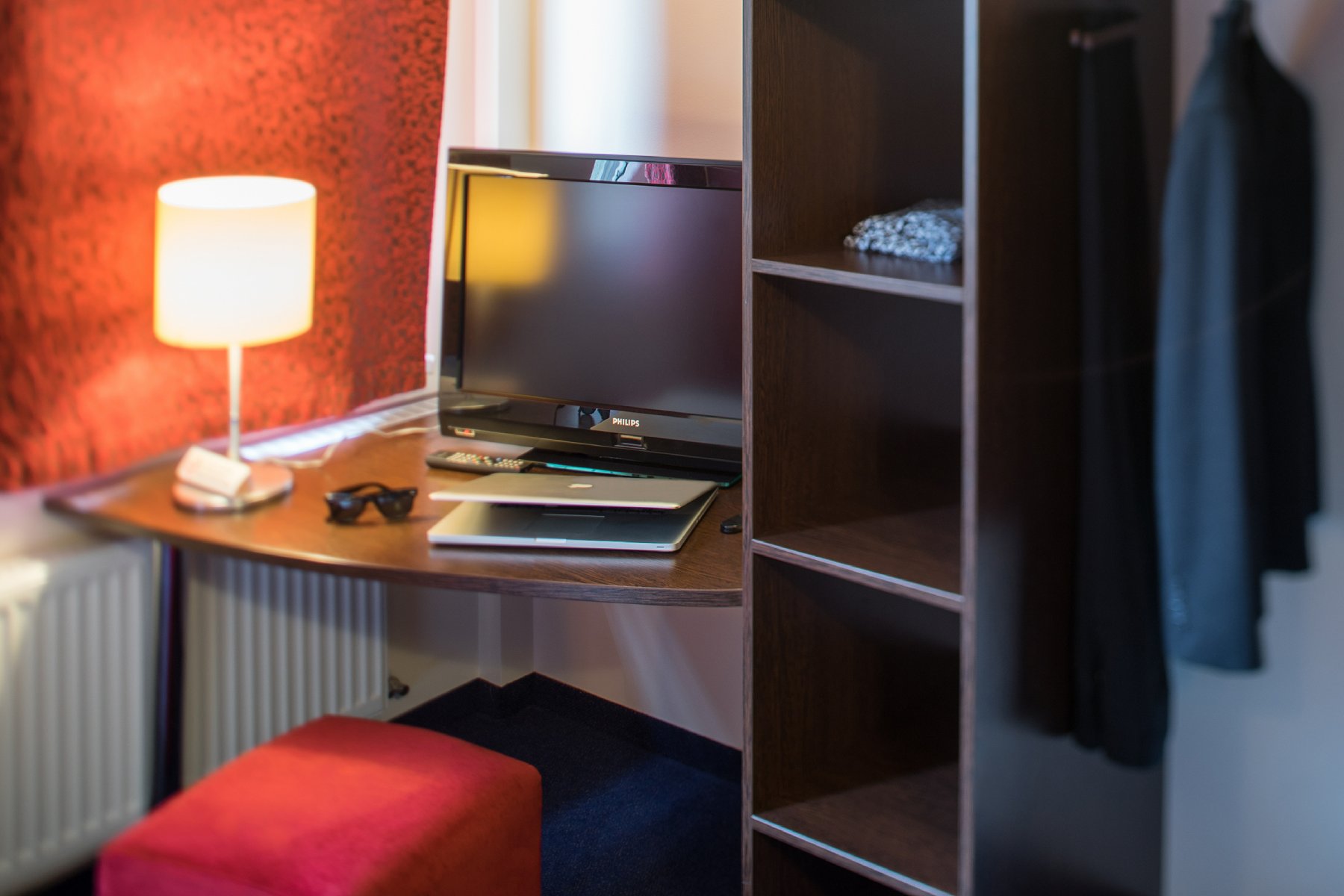 Hotel room work desk with TV, lamp and wardrobe storage